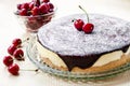 Bird`s Milk souffle cake, covered with chocolate glaze and decorated with ripe cherries