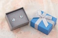 Bird shape with blue heart earring studs in gift box on lace background