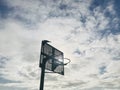 Bird stand on basketball hoop against dramatic back light clouds and sky background. Royalty Free Stock Photo