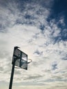 Bird stand on basketball hoop against dramatic backlight blue sky background. Royalty Free Stock Photo