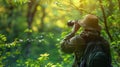 The bird watcher using binocular and searching for the bird in a forest. AIG43. Royalty Free Stock Photo