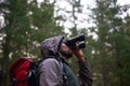 Bird watching, woods and man with binocular, adventure and hiking with trees and peace with hobby. Person, forest or guy Royalty Free Stock Photo