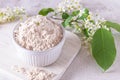 Birdcherry flour in a bowl, on light grey background