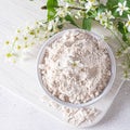 Birdcherry flour in a bowl, top view on grey background