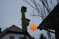 Birdhouse against the background of a Christmas star in the garden in winter. Berlin, Germany