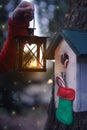 Birdhouse with christmas stocking decoration illuminated by lantern Royalty Free Stock Photo