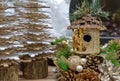 Birdhouse with gold sequins in a Christmas composition with cones and pearls.