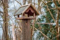 The birdhouse stands on a wooden post