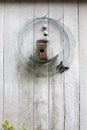 Birdhouse and wire wreath on wall