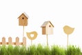 Birdhouses and wooden bird on a background of green grass.