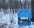 Birds blue coloured feeder with bread inside painted by children