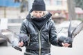 Birds doves eat sunflower seeds from the hands of a beautiful young girl in a black jacket Royalty Free Stock Photo