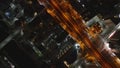 Birds eye shot of streets and buildings in urban borough in night city. Orange color streetlights along thoroughfare
