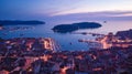 Birds eye view of the evening city during sunset. Aerial photography. Lights on lanterns on dusk. The ships are in the bay. Tiled Royalty Free Stock Photo