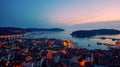 Birds eye view of the evening city during sunset. Aerial photography. Lights on lanterns on dusk. The ships are in the bay. Tiled Royalty Free Stock Photo
