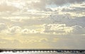 Birds flying above pier through heavenly clouds Royalty Free Stock Photo