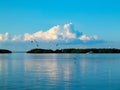 Birds flying over bay with fishing boat and clouds reflecting in water Royalty Free Stock Photo