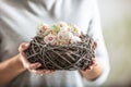 Birds nest full of colorful easter eggs held in womens hands Royalty Free Stock Photo