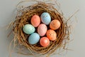A birds nest with pastel Easter eggs, each uniquely painted with unique pattern on a solid background Royalty Free Stock Photo