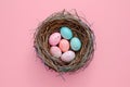 A birds nest with pastel Easter eggs, each uniquely painted with unique pattern on a solid background Royalty Free Stock Photo