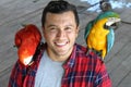 Birds tamer working with two macaws