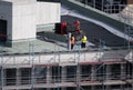 Birdseye view of roofer waterproofing the flat roof of a commercial building.