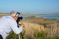Birdwatcher with digital camera in moorland natural reserve