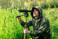 Birdwatcher with a spotting scope and notepad among the tall grass in the valley Royalty Free Stock Photo
