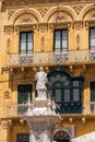 Birgu, Malta Victory square with statue detail before limestone buildings and balconies in the old city Citta Vittoriosa