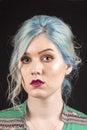 Caucasian female model, Age 22, Blue dyed hair, Red lips, green and red shirt. Isolated on black background. Upper torso. Belly ex Royalty Free Stock Photo