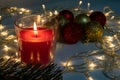 Birning red christmas candle with decorations at night, christmas eve mistery concept