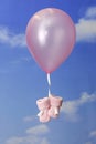 Birth concept:balloon carrying pink baby booties Royalty Free Stock Photo