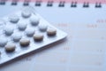 Close up of birth control pills and calendar on table Royalty Free Stock Photo