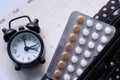 Birth control pills , clock and calendar, close up Royalty Free Stock Photo
