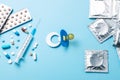 Birth control pills, an injection syringe and condom in a package on blue background. The concept of choosing method of Royalty Free Stock Photo