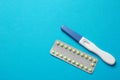 Birth control pills and pregnancy test on light blue background, top view. Space for text Royalty Free Stock Photo