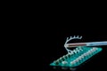 Birth Control symbole- IUD and contraceptive Pills on on black background Royalty Free Stock Photo