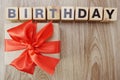 Birthday alphabet wooden cube with gift box present on wooden background Royalty Free Stock Photo