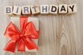 Birthday alphabet wooden cube with gift box present on wooden background Royalty Free Stock Photo