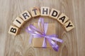 Birthday alphabet wooden cube with gift box present on wooden background Royalty Free Stock Photo