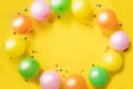 Birthday background. Colorfull balloons and candies on yellow table. Place for your text Royalty Free Stock Photo