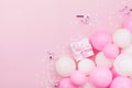 Birthday background with gift or present box, balloons and confetti on pink pastel table from above. Flat lay style.