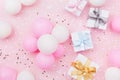 Birthday background with gift or present box, balloons and confetti on pink pastel table top view. Flat lay composition. Royalty Free Stock Photo