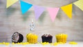 Birthday background with number 2. Beautiful birthday card with colorful garlands, a muffin with a candle burning copyspace. Royalty Free Stock Photo