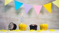 Birthday background with number 3. Beautiful birthday card with colorful garlands, a muffin with a candle burning copyspace. Royalty Free Stock Photo