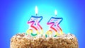 Birthday cake with a burning birthday candle. Number 33. Background changes color
