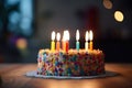 Birthday cake with burning candles on a table in the dark room, closeup, A Birthday cake with colorful happy birthday candles