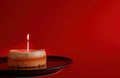 a birthday cake and candle, with a birthday message on a red background, light red and crimson