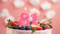 Birthday cake candle number 81. Candle and cake on pink background and fire by lighter. Close-up and slow motion