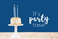 Birthday cake with candles on classic blue with It`s party time wording. Birthday party celebration concept Royalty Free Stock Photo